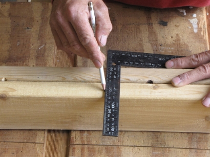Marking baluster spacing on a 2x4 rail with a speed square and pencil