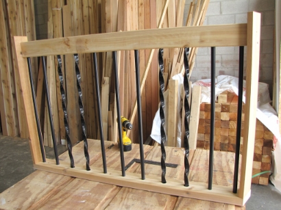 Top rail being lowered onto aluminum balusters to complete the railing assembly