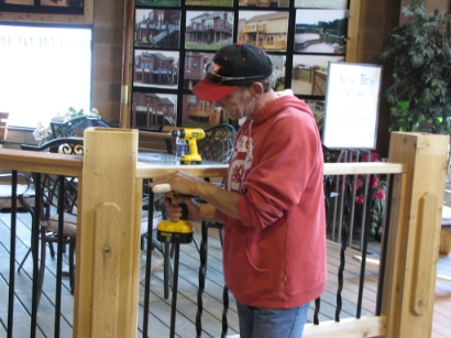 Deck builder securing railing assembly to post with a cordless drill