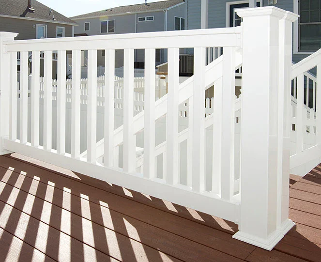 White vinyl deck railing with square balusters installed on brown composite decking